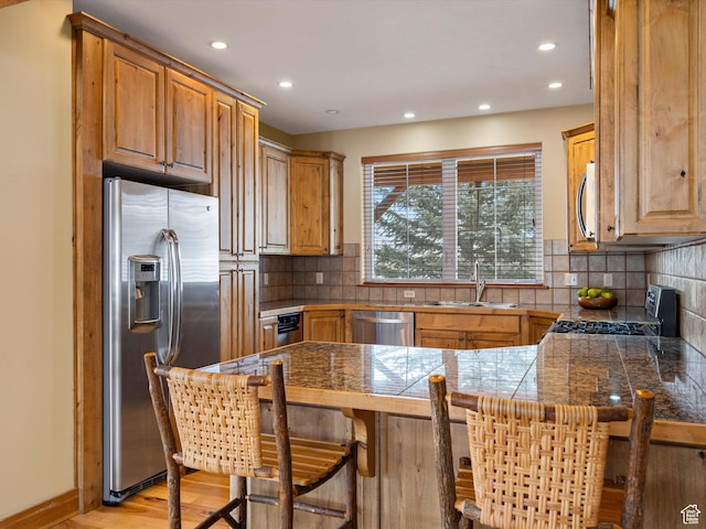 1173 S Innsbruck Dr, Huntsville, UT 84317 - kitchen with a sink, tile counters, a breakfast bar, a peninsula, and appliances with stainless steel finishes