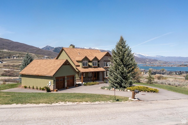 1173 S Innsbruck Dr, Huntsville, UT 84317 - view of front of house with a front yard, a garage, a water and mountain view, a chimney, and concrete driveway