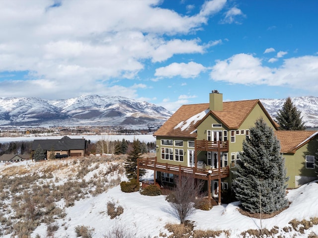 1173 S Innsbruck Dr, Huntsville, UT 84317 - snow covered rear of property featuring a chimney, stucco siding, and a deck with mountain view