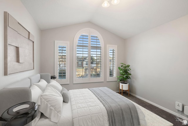 bedroom featuring lofted ceiling, carpet flooring, and baseboards