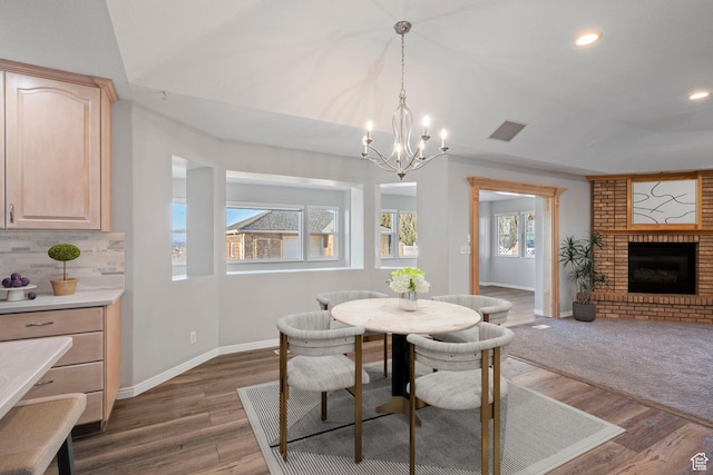 dining space with a chandelier, a fireplace, baseboards, dark wood-type flooring, and recessed lighting