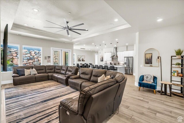 5159 W 2200 S, Hurricane, UT 84737 - living area with baseboards, a ceiling fan, light wood-style flooring, a tray ceiling, and recessed lighting