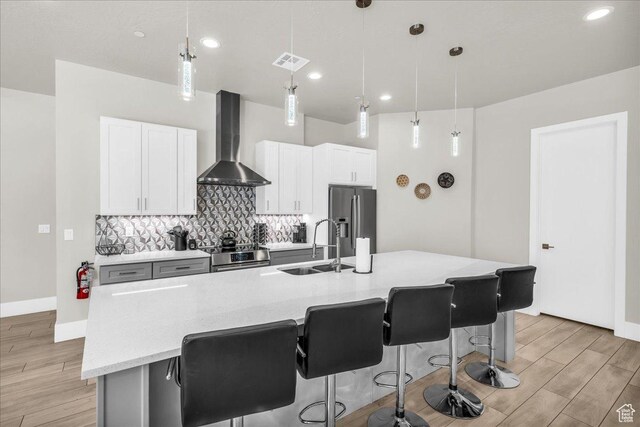 5159 W 2200 S, Hurricane, UT 84737 - kitchen with stainless steel appliances, a sink, visible vents, wall chimney range hood, and backsplash