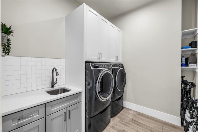 5159 W 2200 S, Hurricane, UT 84737 - laundry area featuring cabinet space, light wood-style floors, a sink, independent washer and dryer, and baseboards