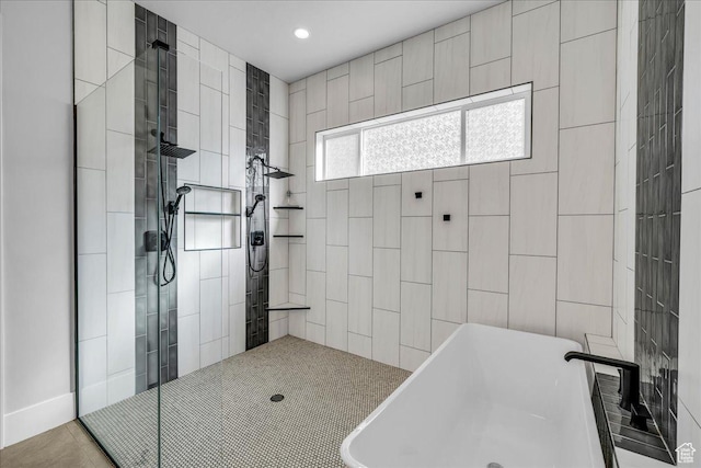 bathroom with tiled shower, a freestanding tub, and recessed lighting