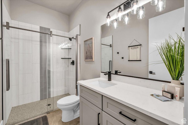 bathroom with a stall shower, vanity, and toilet