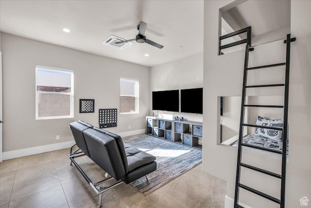 living room with a ceiling fan, a wealth of natural light, visible vents, and baseboards