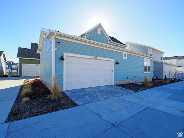 view of side of property with a garage and concrete driveway