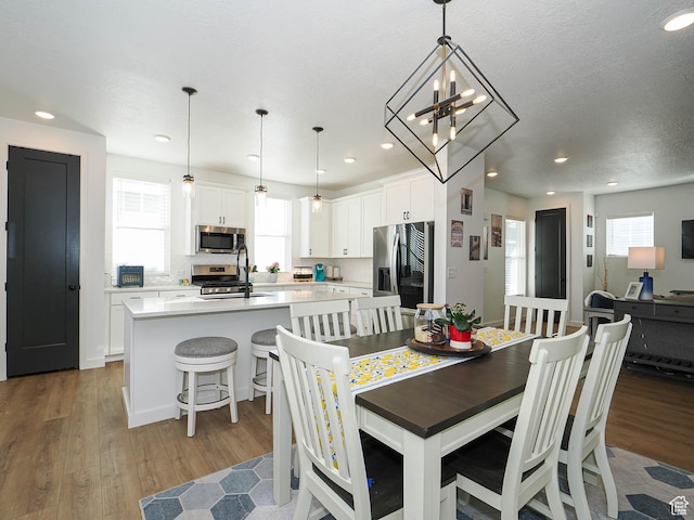 dining space with wood finished floors, a wealth of natural light, and recessed lighting