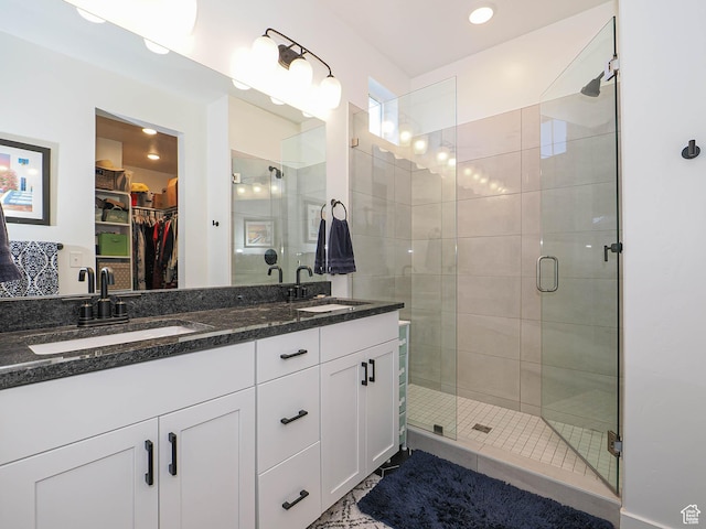 full bathroom featuring a shower stall, a spacious closet, and a sink