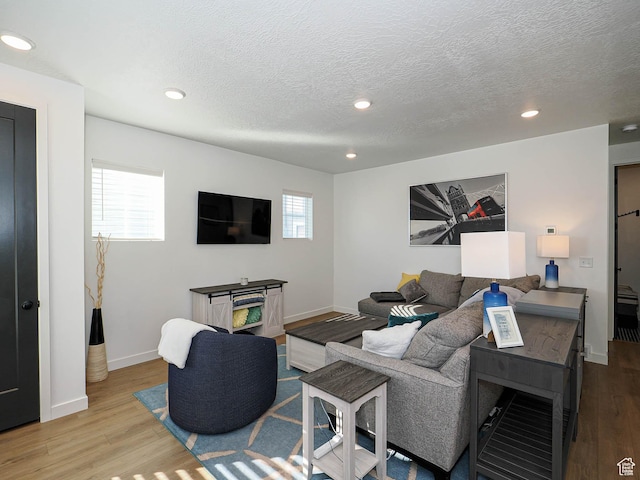 living area featuring recessed lighting, baseboards, and wood finished floors