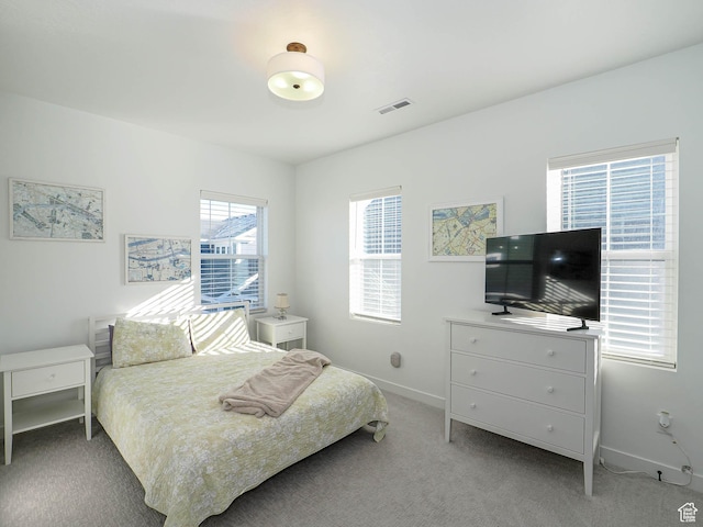 bedroom with light colored carpet, visible vents, and baseboards