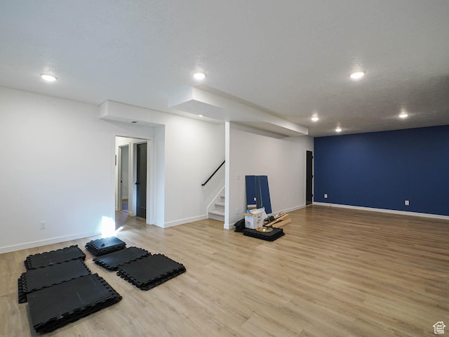 exercise room with light wood-style floors, baseboards, and recessed lighting