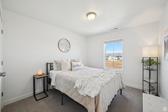 carpeted bedroom featuring baseboards, visible vents, and a textured ceiling
