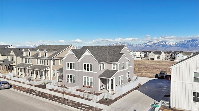 view of front of property with board and batten siding, a shingled roof, a residential view, and concrete driveway