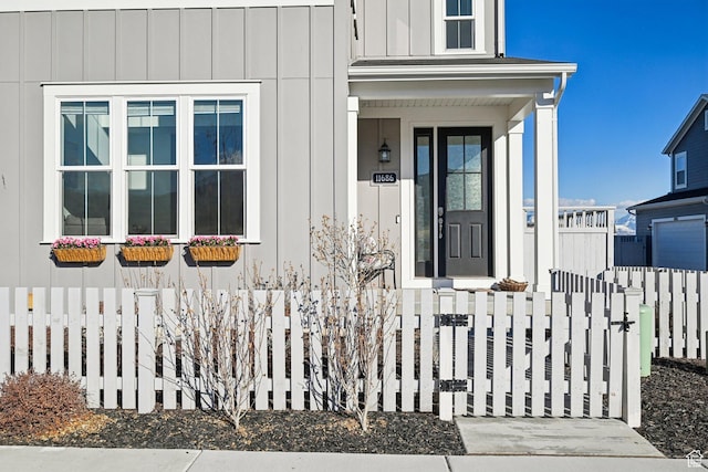 entrance to property with board and batten siding and fence