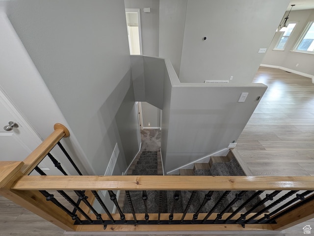 stairway with wood finished floors and baseboards