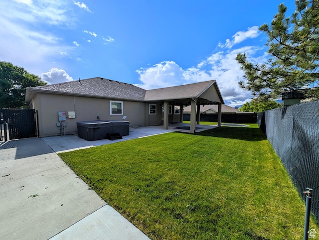 back of house with a hot tub, a patio, stucco siding, and a shingled roof