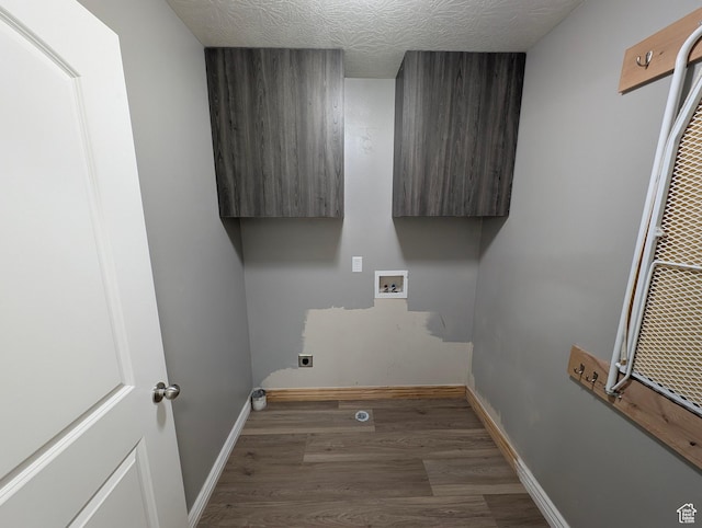 laundry area featuring cabinet space, electric dryer hookup, washer hookup, wood finished floors, and baseboards