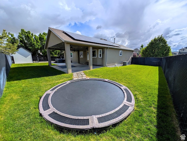 back of property with solar panels, ceiling fan, a patio, stucco siding, and central AC unit