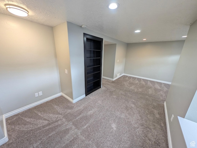 finished below grade area with carpet, recessed lighting, baseboards, and a textured ceiling