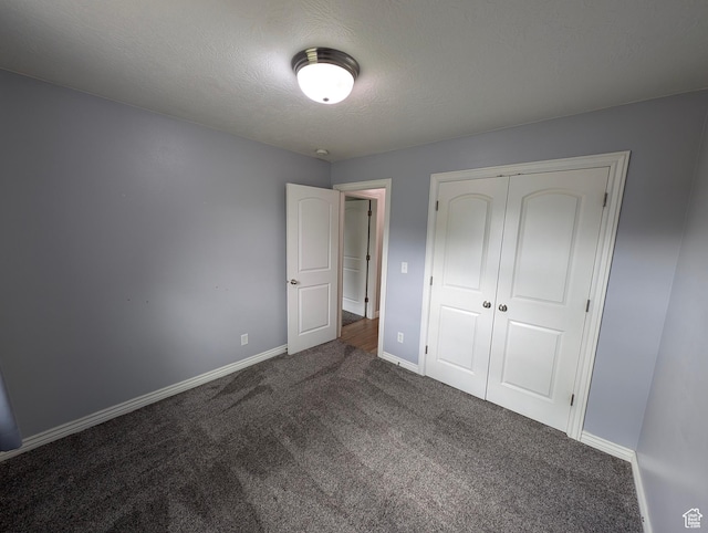 unfurnished bedroom with carpet floors, baseboards, a closet, and a textured ceiling