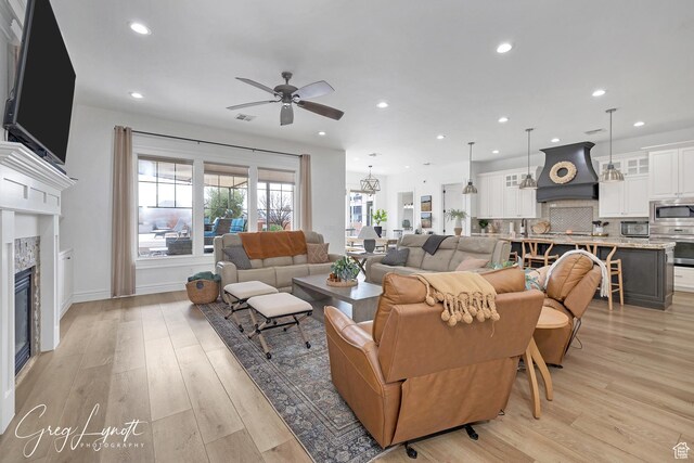 395 W Granite Dr, Washington, UT 84780 - living area with a ceiling fan, a glass covered fireplace, recessed lighting, light wood-style flooring, and baseboards
