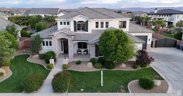 395 W Granite Dr, Washington, UT 84780 - view of front of home featuring stone siding, stucco siding, a gate, driveway, and a residential view