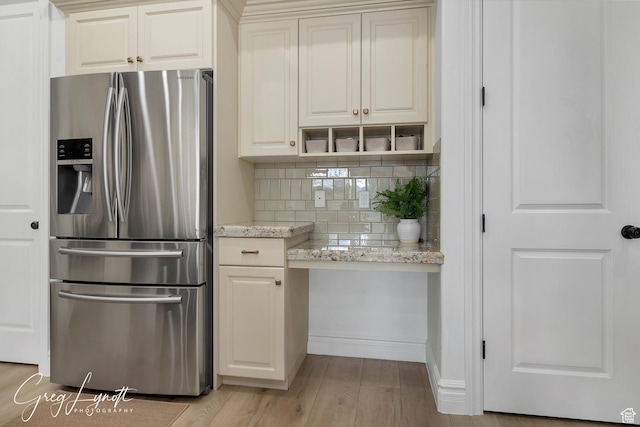 395 W Granite Dr, Washington, UT 84780 - kitchen with stainless steel fridge with ice dispenser, tasteful backsplash, light wood-style flooring, light stone counters, and built in study area