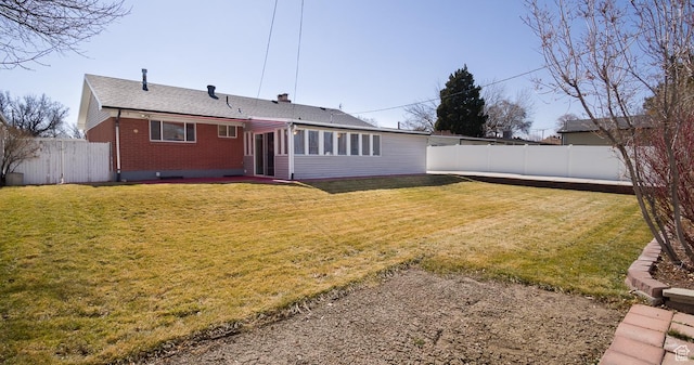 3664 W 3965 S, West Valley City, UT 84120 - rear view of house featuring a chimney, brick siding, a yard, and a fenced backyard