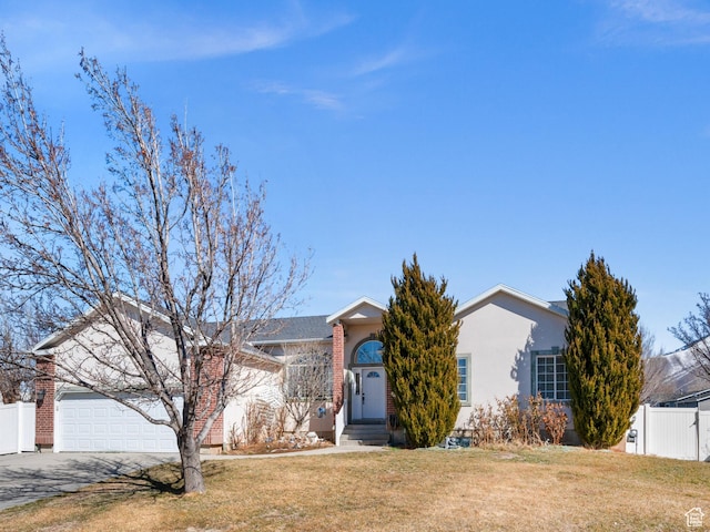 view of front of home featuring a garage, fence, driveway, stucco siding, and a front yard