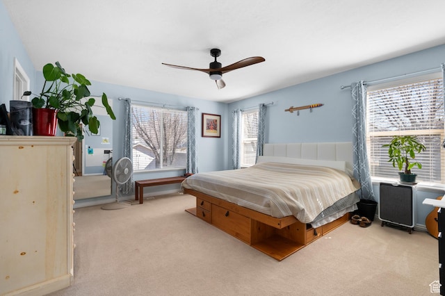 bedroom featuring baseboards, a ceiling fan, and light colored carpet