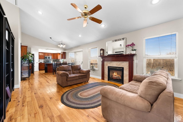 living area with a fireplace, light wood finished floors, lofted ceiling, recessed lighting, and baseboards