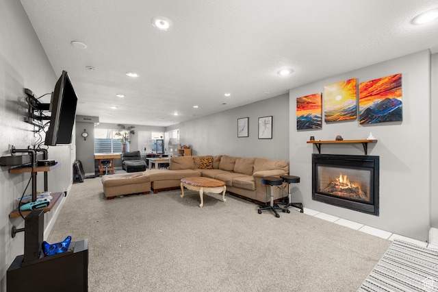 living room with a glass covered fireplace, a textured ceiling, and recessed lighting
