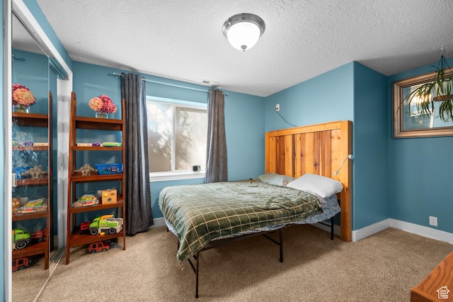 bedroom with carpet, visible vents, baseboards, and a textured ceiling