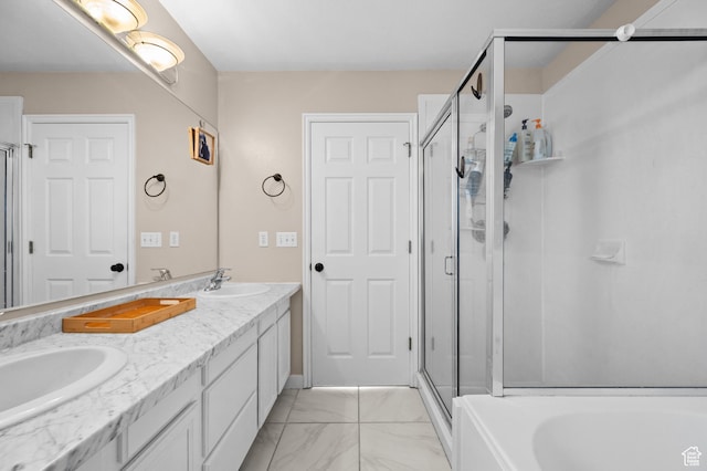 full bathroom with marble finish floor, a shower stall, and a sink