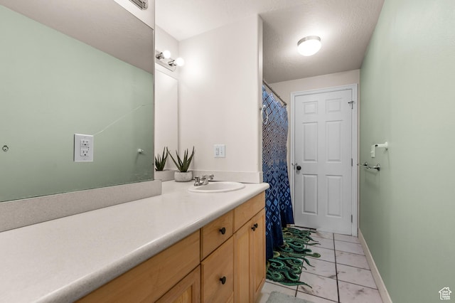 bathroom featuring marble finish floor, baseboards, and vanity