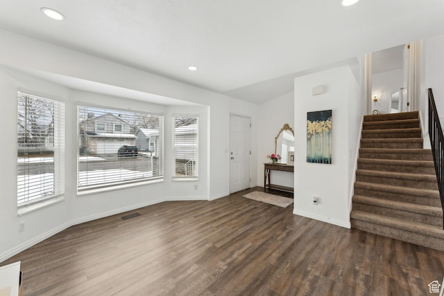 interior space featuring dark wood finished floors, recessed lighting, visible vents, stairway, and baseboards