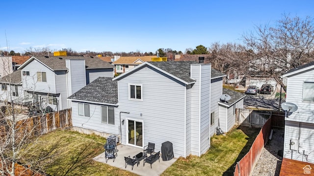rear view of house featuring a shingled roof, a residential view, a fenced backyard, and a patio
