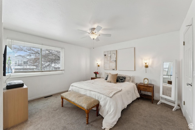 bedroom featuring light carpet, baseboards, visible vents, and a ceiling fan