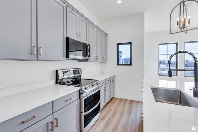 5328 W Dosh Ln Unit 40, Highland, UT 84003 - kitchen featuring a sink, appliances with stainless steel finishes, light wood-type flooring, and gray cabinets