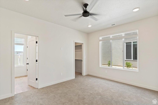 818 W 1100 N Unit 140, North Salt Lake, UT 84054 - unfurnished bedroom featuring light carpet, a spacious closet, a textured ceiling, ceiling fan, and recessed lighting