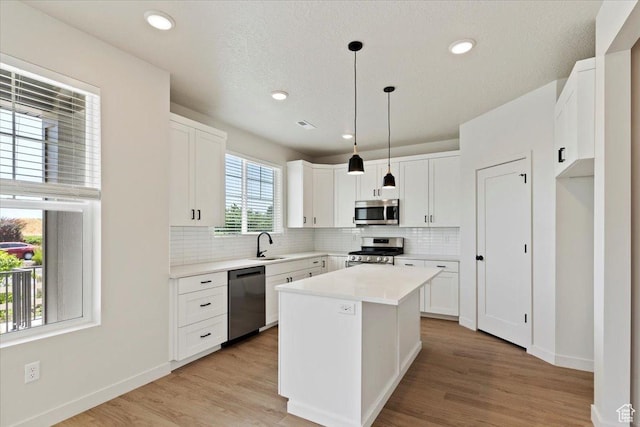 818 W 1100 N Unit 140, North Salt Lake, UT 84054 - kitchen featuring appliances with stainless steel finishes, backsplash, white cabinets, light countertops, and a kitchen island