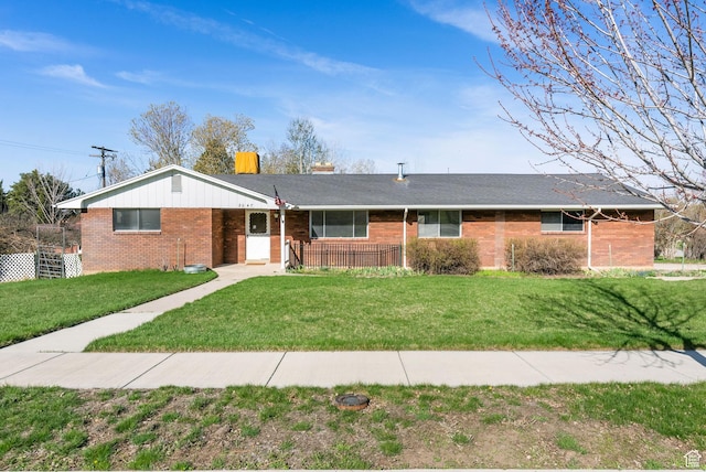 ranch-style home featuring brick siding and a front lawn