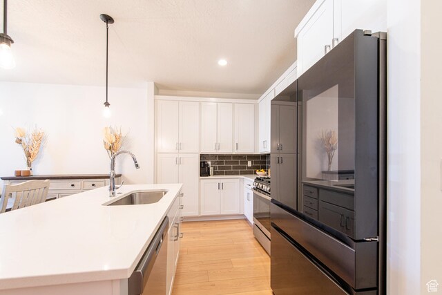 695 W Claystone Dr, St George, UT 84790 - kitchen featuring light countertops, backsplash, light wood-style flooring, appliances with stainless steel finishes, and a sink