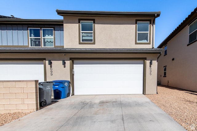 695 W Claystone Dr, St George, UT 84790 - view of front facade featuring driveway, board and batten siding, an attached garage, and stucco siding
