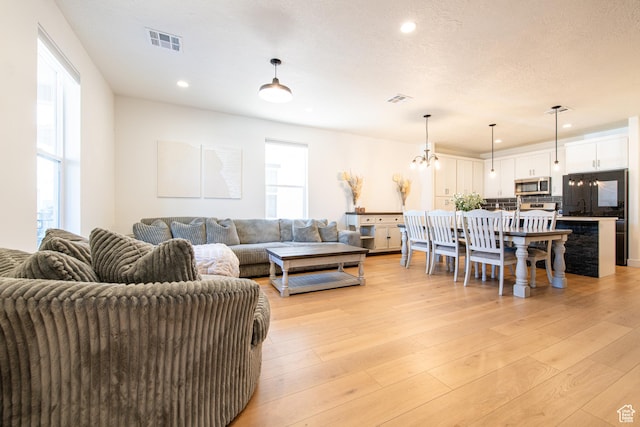 695 W Claystone Dr, St George, UT 84790 - living room with a textured ceiling, visible vents, and light wood-style floors