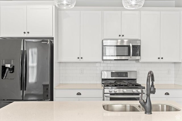 5927 W Lake Ave S, South Jordan, UT 84009 - kitchen featuring backsplash, appliances with stainless steel finishes, white cabinets, and a sink