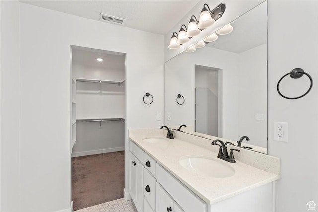 5927 W Lake Ave S, South Jordan, UT 84009 - full bathroom featuring double vanity, a sink, visible vents, and a walk in closet