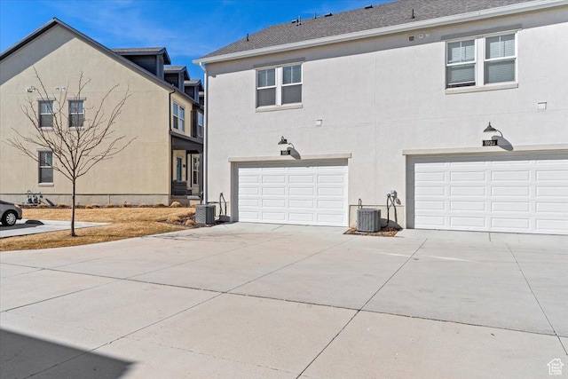 5927 W Lake Ave S, South Jordan, UT 84009 - exterior space with cooling unit, driveway, an attached garage, and stucco siding